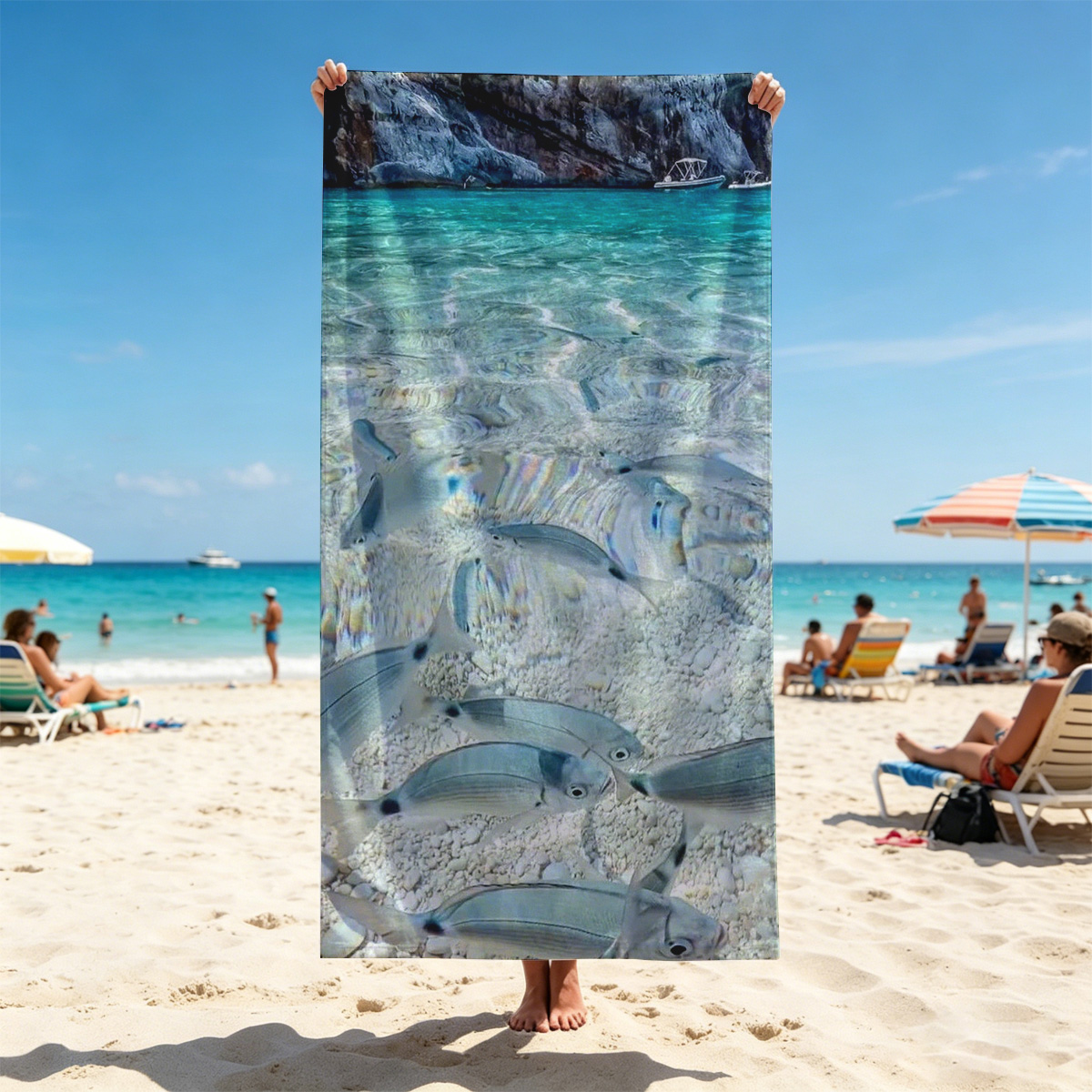 Clear waters reveal schools of fish swimming near a rocky shore with boats in the distance. - Beach towels