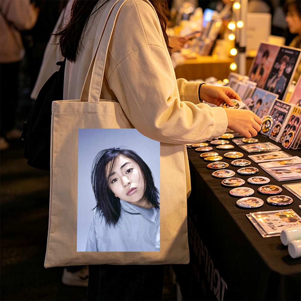 Yuki Kajiura in a Serene Portrait Wearing a Light Blue Collared Shirt Against a Soft Gray Background - Canvas tote bags