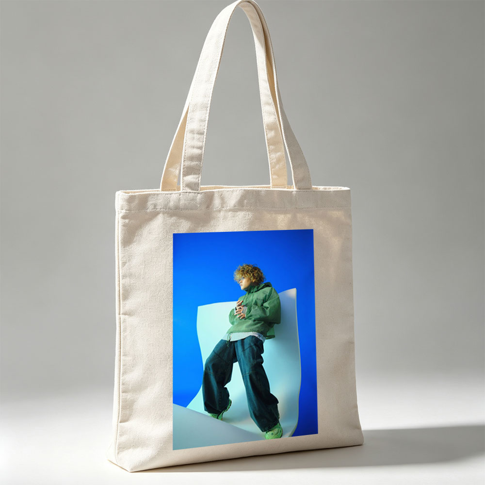 Jaden Smith in a Fashion Shoot Wearing Oversized Green Jacket and Baggy Jeans Against a Blue Background - Canvas tote bags