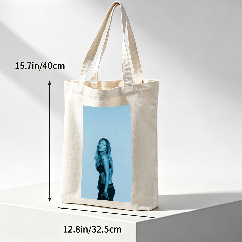 Khloe Kardashian in a Bold Pose with Heart Tattoo and Edgy Fashion Against a Cool Blue Backdrop - Canvas tote bags