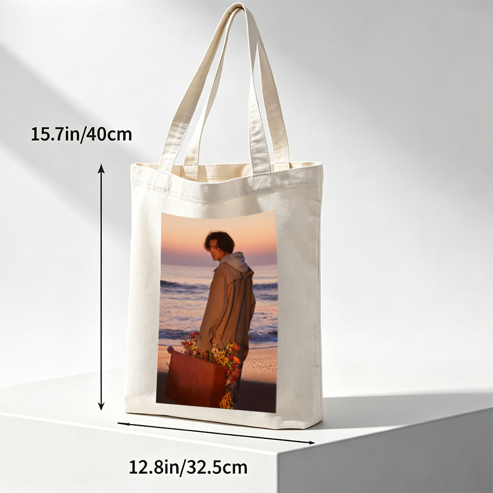 Takuya Kimura on Beach at Sunset Holding Flower-Adorned Suitcase - Canvas tote bags