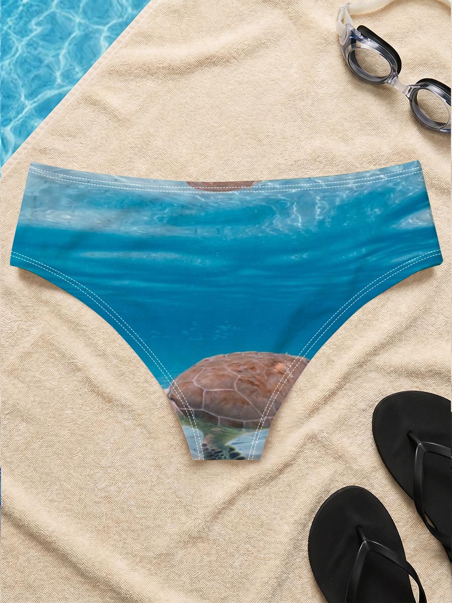 Sea turtle swims gracefully in clear blue water with fish below, sunlight filtering through the surface. -  Men's swim trunks