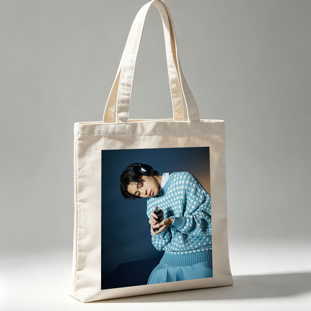 Jaden Smith in a Stylish Blue Sweater Holding a Perfume Bottle with Headphones On - Canvas tote bags