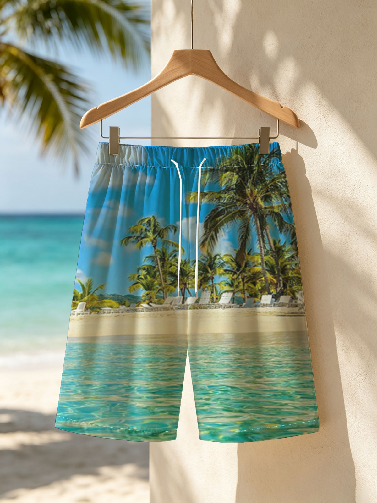 Crystal clear waters meet sandy beach with palm trees and lounge chairs under a bright blue sky. -  Beach shorts