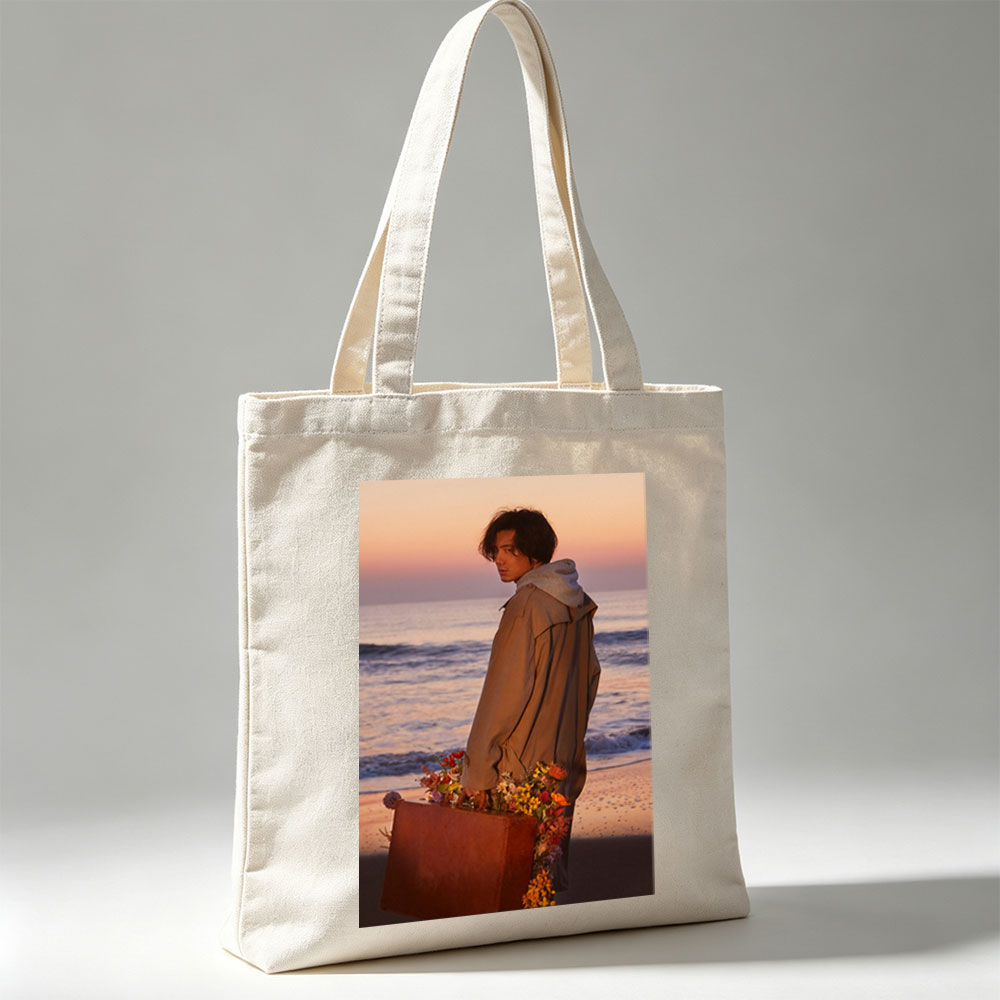 Takuya Kimura on Beach at Sunset Holding Flower-Adorned Suitcase - Canvas tote bags