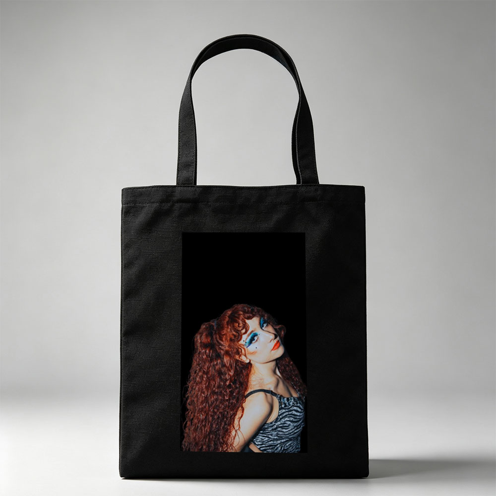 Chappell Roan in a Dramatic Pose with Vibrant Red Hair and Bold Blue Eye Makeup Against a Dark Background - Canvas tote bags