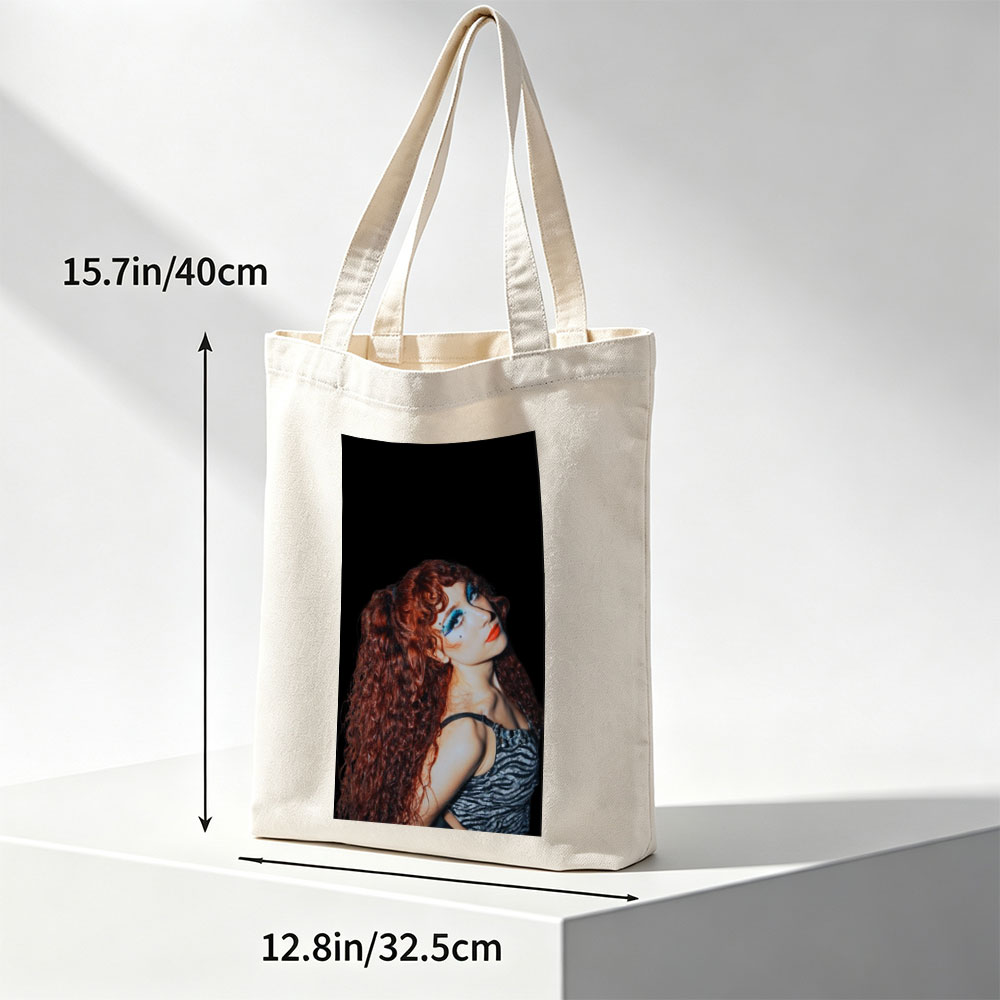 Chappell Roan in a Dramatic Pose with Vibrant Red Hair and Bold Blue Eye Makeup Against a Dark Background - Canvas tote bags