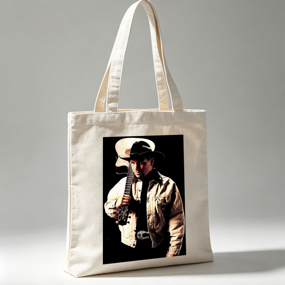 Garth Brook Holding Acoustic Guitar in Cowboy Attire Against Dark Background - Canvas tote bags
