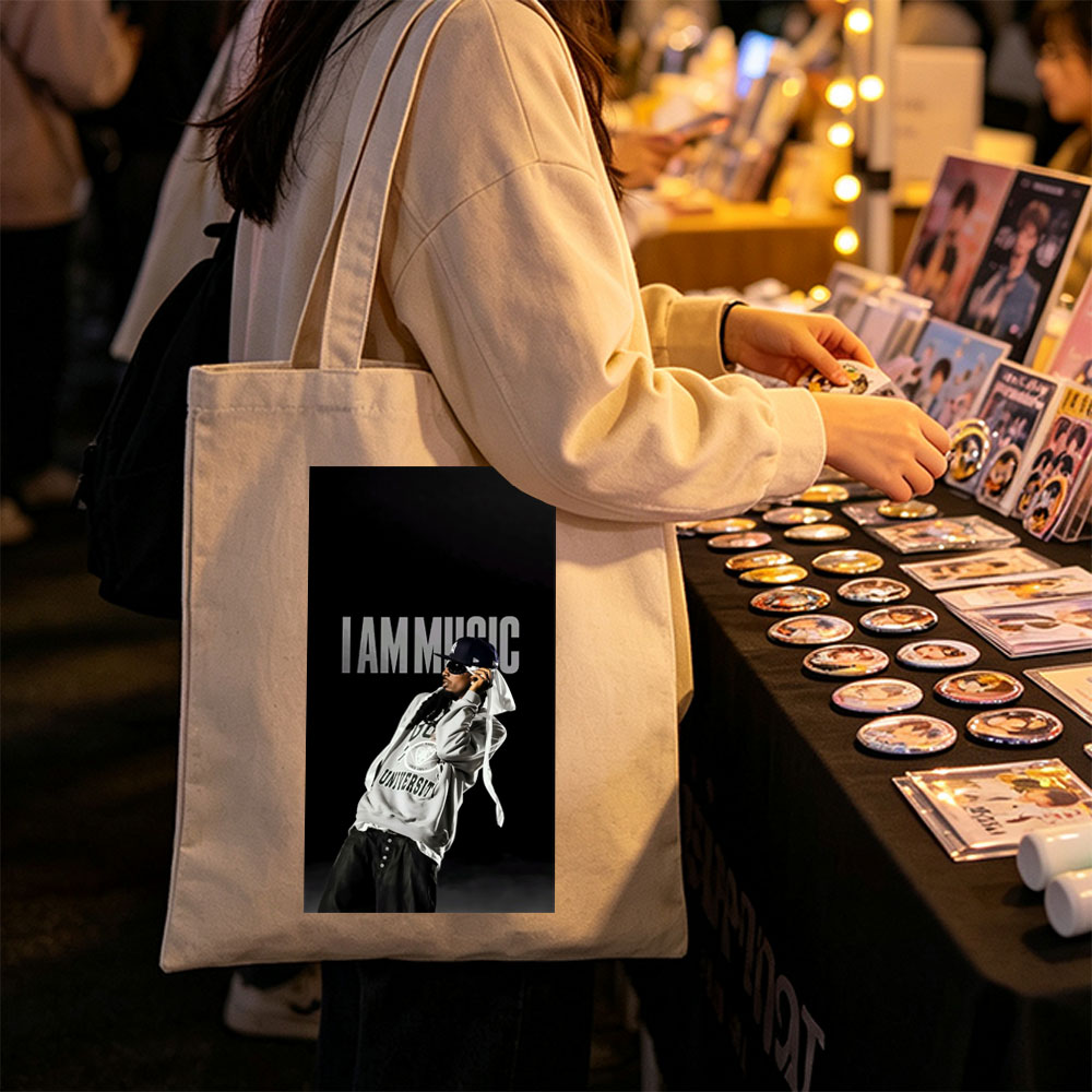 IamMusic Artist in Stylish Pose Wearing Hoodie and Cap Against Dark Background - Canvas tote bags