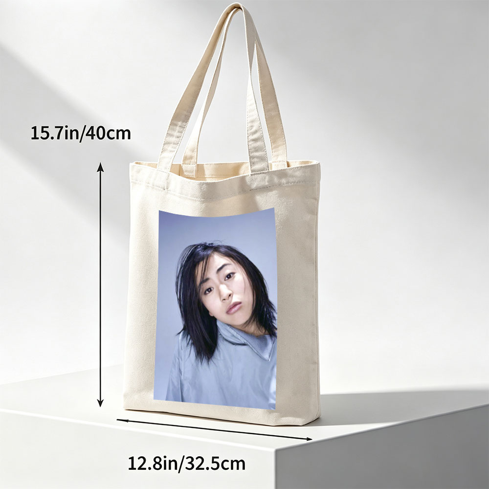 Yuki Kajiura in a Serene Portrait Wearing a Light Blue Collared Shirt Against a Soft Gray Background - Canvas tote bags