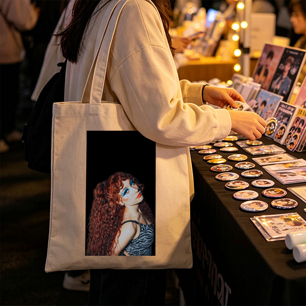 Chappell Roan in a Dramatic Pose with Vibrant Red Hair and Bold Blue Eye Makeup Against a Dark Background - Canvas tote bags