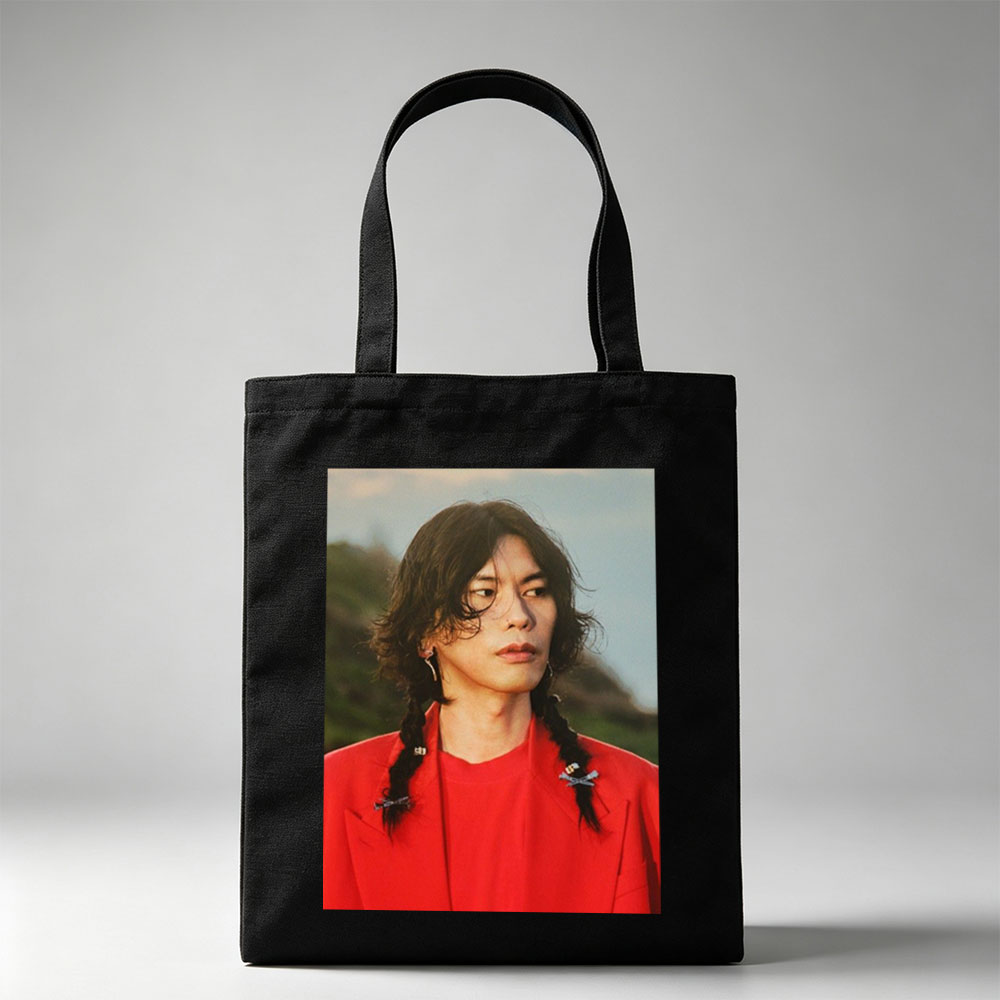 Miyavi in a Bold Red Outfit with Braided Hair and Crossed Pins, Standing Against a Natural Backdrop - Canvas tote bags