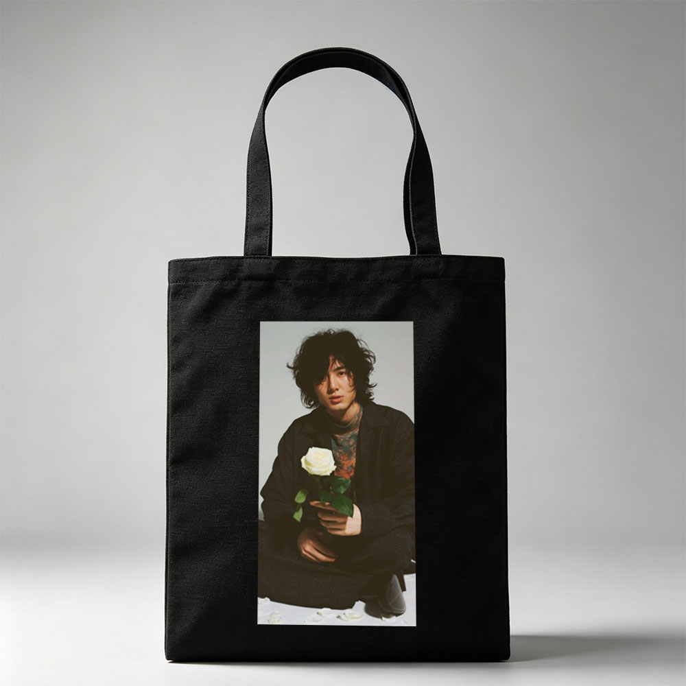 Yosuke Sugino Holding a White Rose in a Stylish Black Outfit with Petals Scattered Around - Canvas tote bags