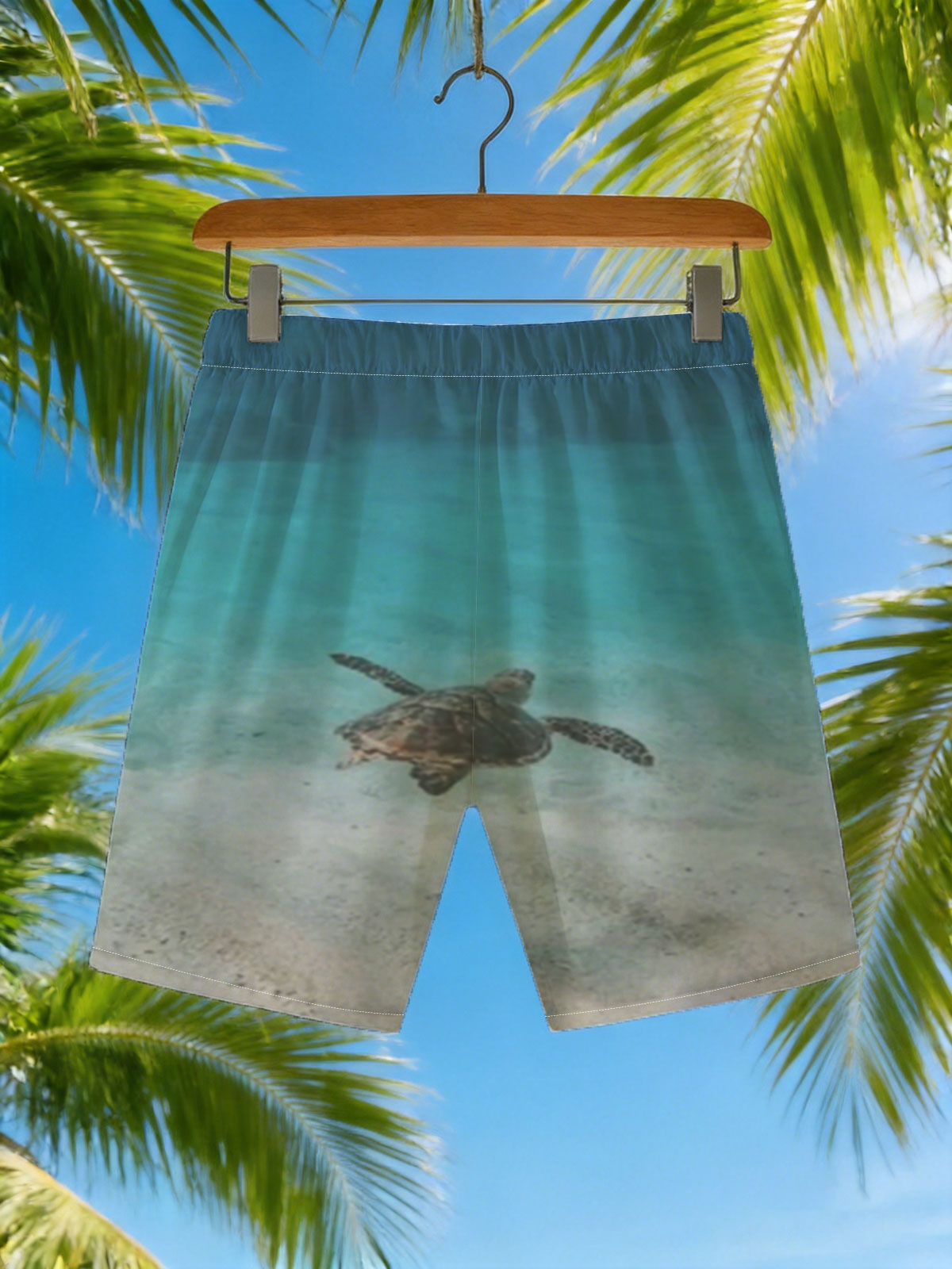 Sea turtle swimming in clear blue water over sandy ocean floor -  Beach shorts
