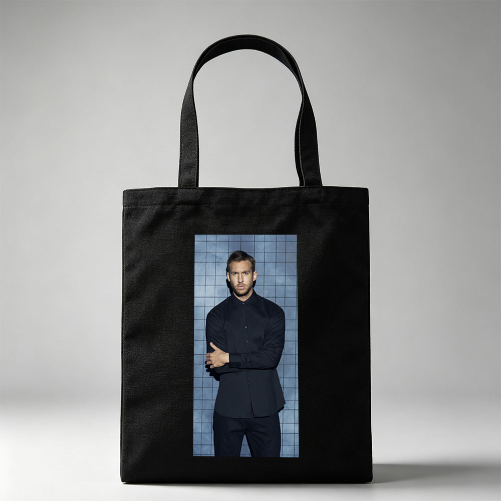 Calvin Harris in a Black Shirt and Pants Standing Against a Blue Tiled Wall with Arms Crossed - Canvas tote bags