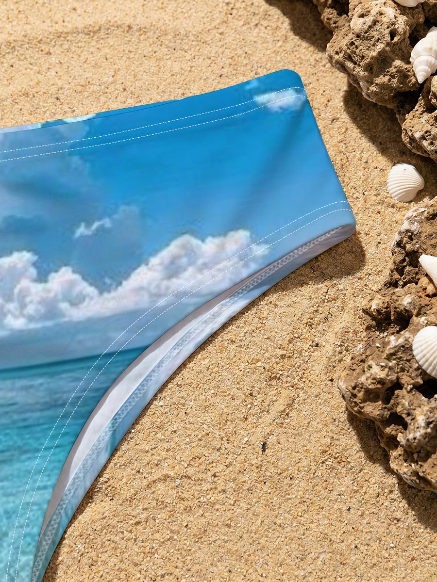 Crystal clear turquoise waters meet soft sandy beach under a vibrant blue sky with fluffy white clouds. -  Men's swim trunks