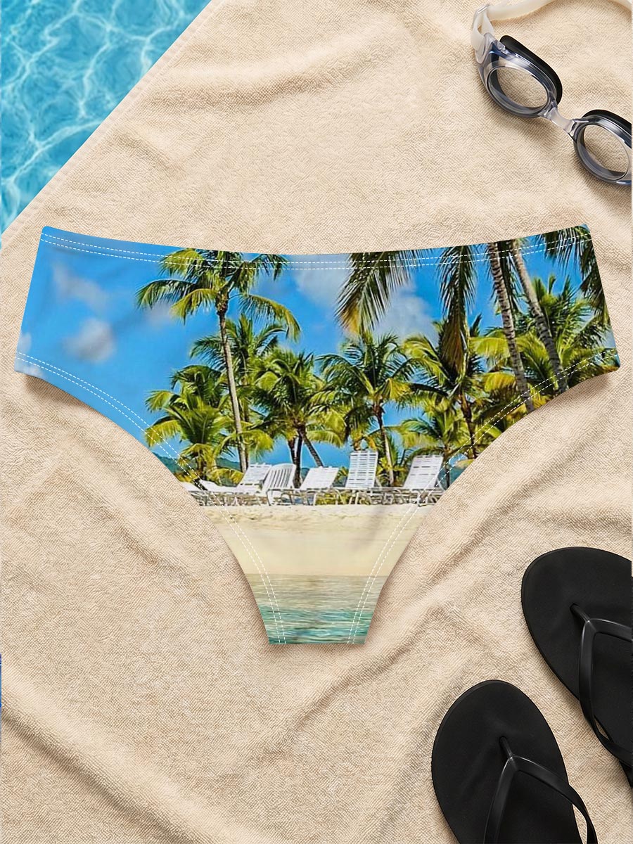 Crystal clear waters meet sandy beach with palm trees and lounge chairs under a bright blue sky. -  Men's swim trunks