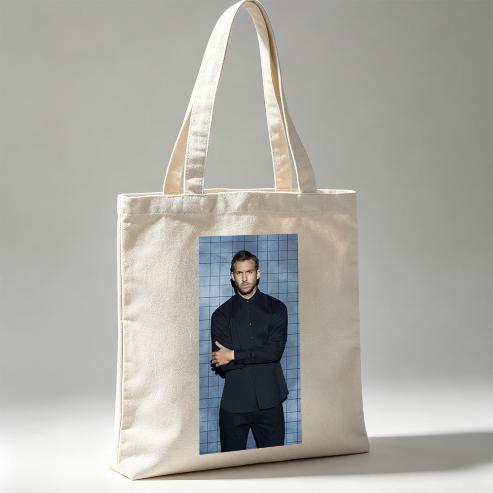 Calvin Harris in a Black Shirt and Pants Standing Against a Blue Tiled Wall with Arms Crossed - Canvas tote bags