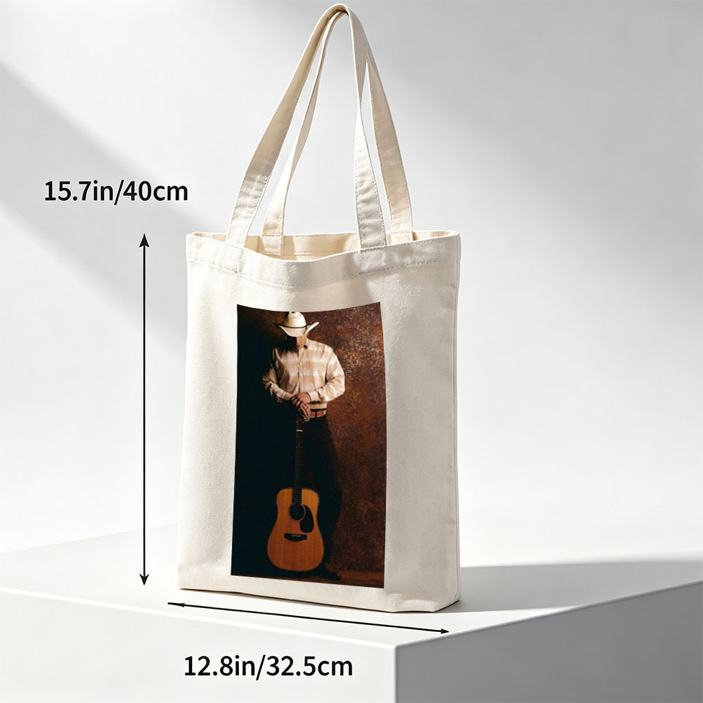 George Strait Holding Acoustic Guitar in Cowboy Attire Against Rustic Background - Canvas tote bags