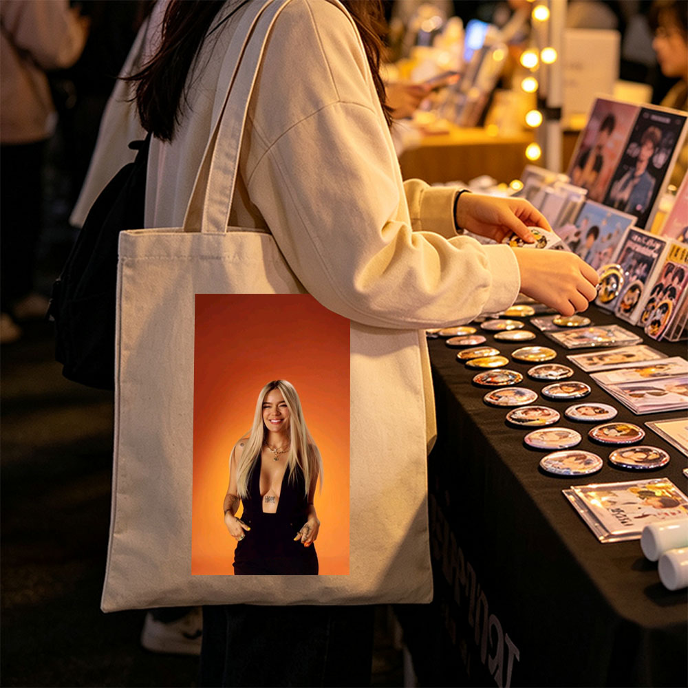 Bebe Rexha in a Bold Black Outfit Against a Vibrant Orange Background, Smiling with Confidence - Canvas tote bags