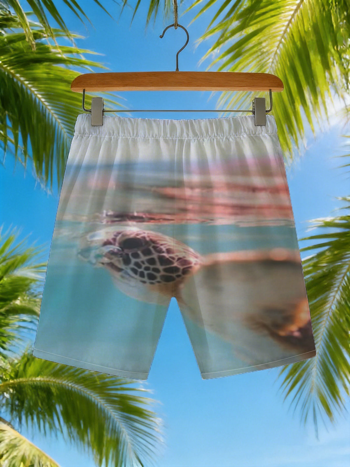 Sea turtle swimming at surface, half above water, clear blue ocean backdrop. -  Beach shorts