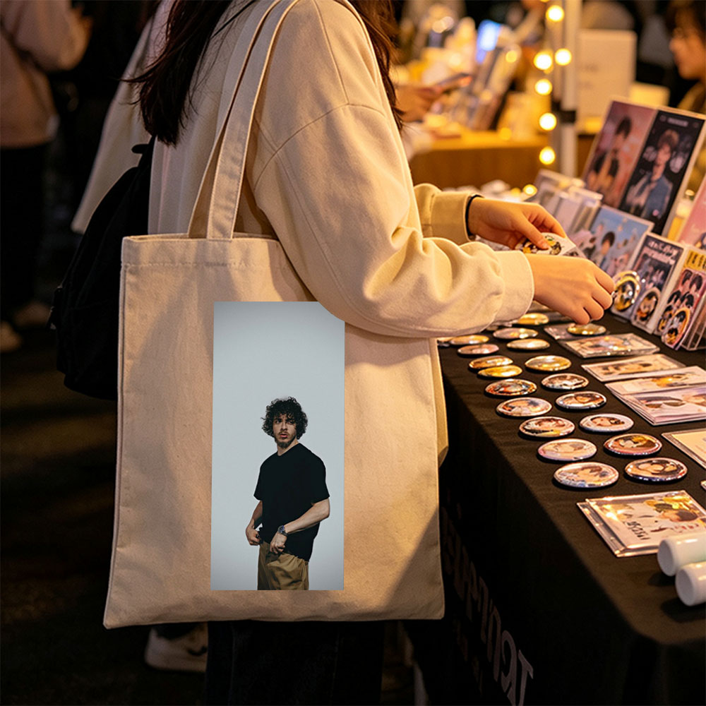 Jack Whitehall in a Casual Pose Wearing a Black T-Shirt and Beige Pants Against a Neutral Background - Canvas tote bags