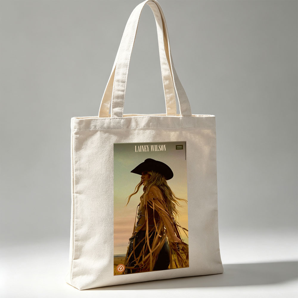 Lainey Wilson in a Cowboy Outfit Standing in a Field at Sunset - Canvas tote bags