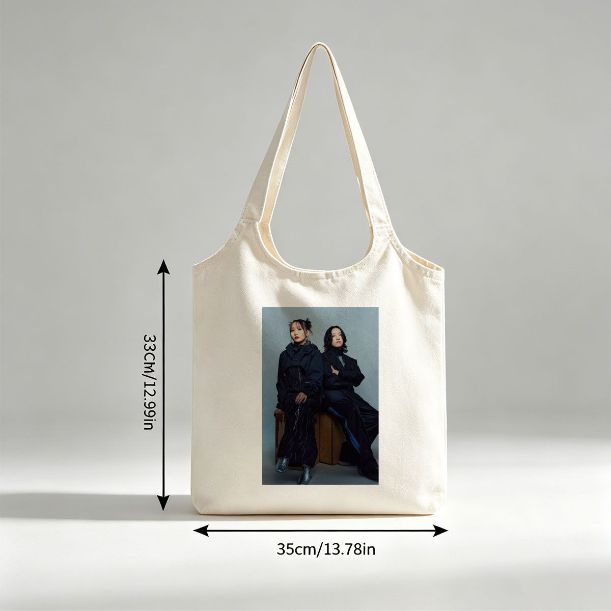 YOASOBI in a Stylish Studio Portrait Featuring Two Members Dressed in Dark, Edgy Fashion Sitting on Wooden Crates Against a Neutral Background - Canvas shoulder bags/