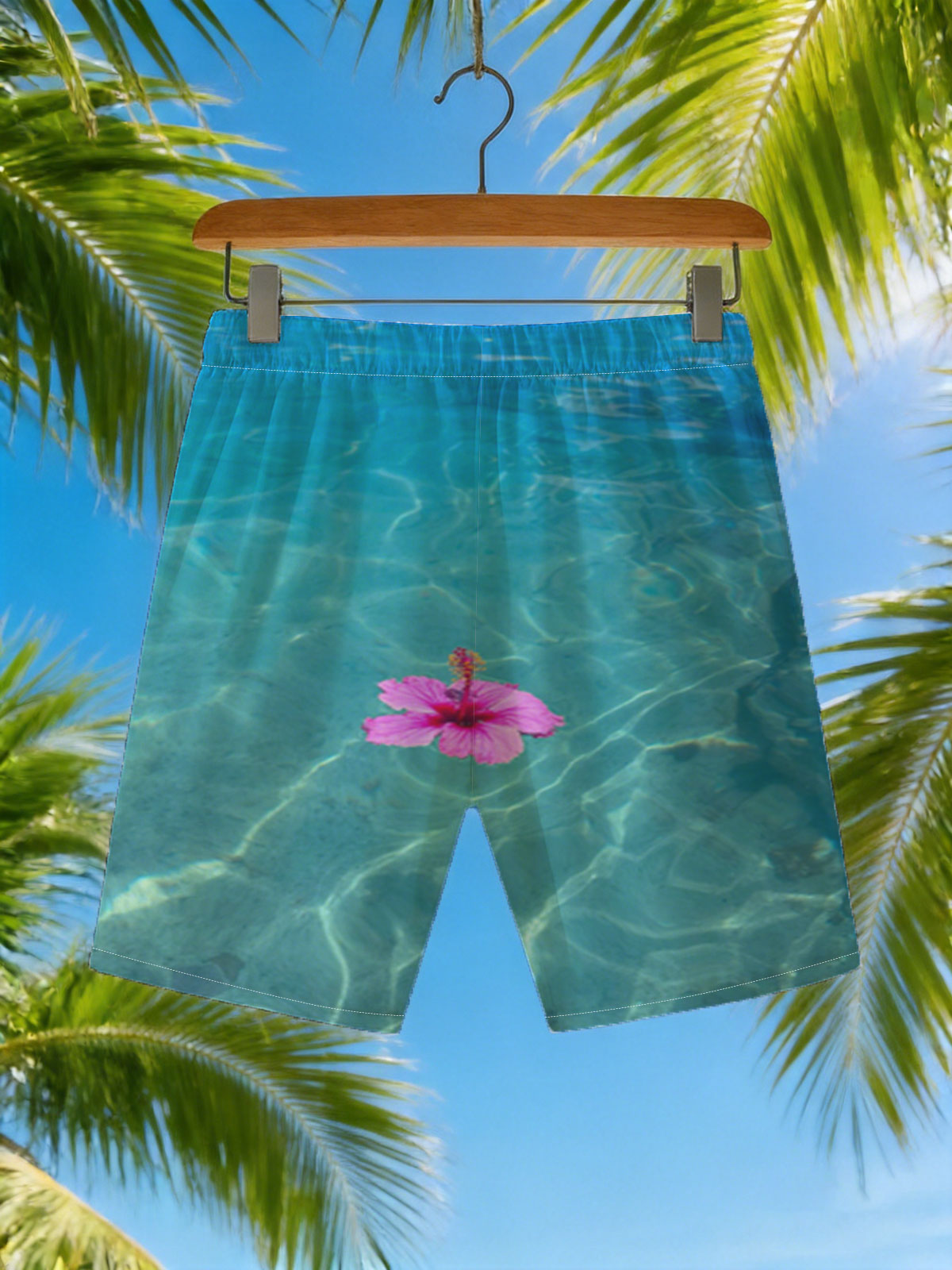 Pink hibiscus floating on crystal clear turquoise water -  Beach shorts