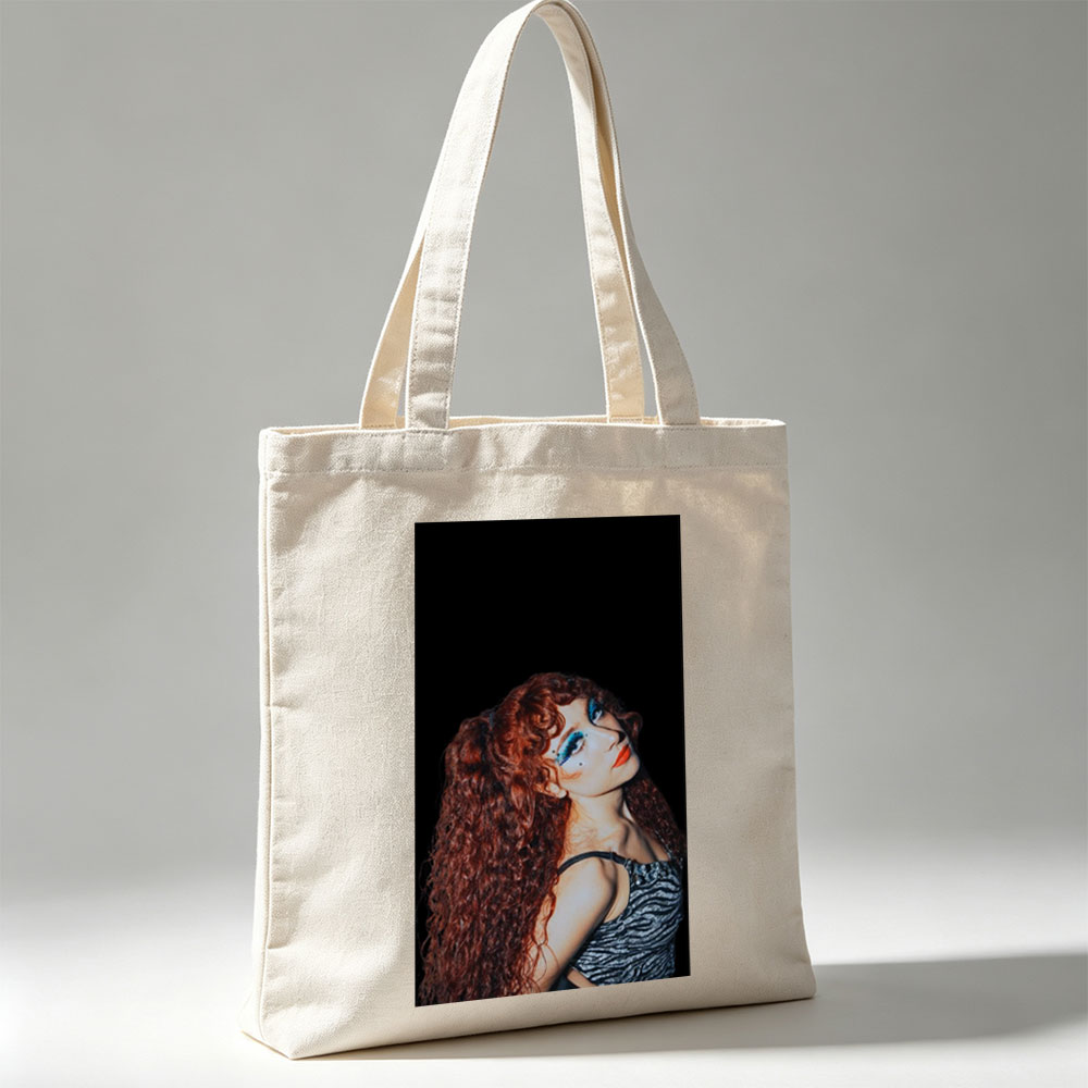 Chappell Roan in a Dramatic Pose with Vibrant Red Hair and Bold Blue Eye Makeup Against a Dark Background - Canvas tote bags