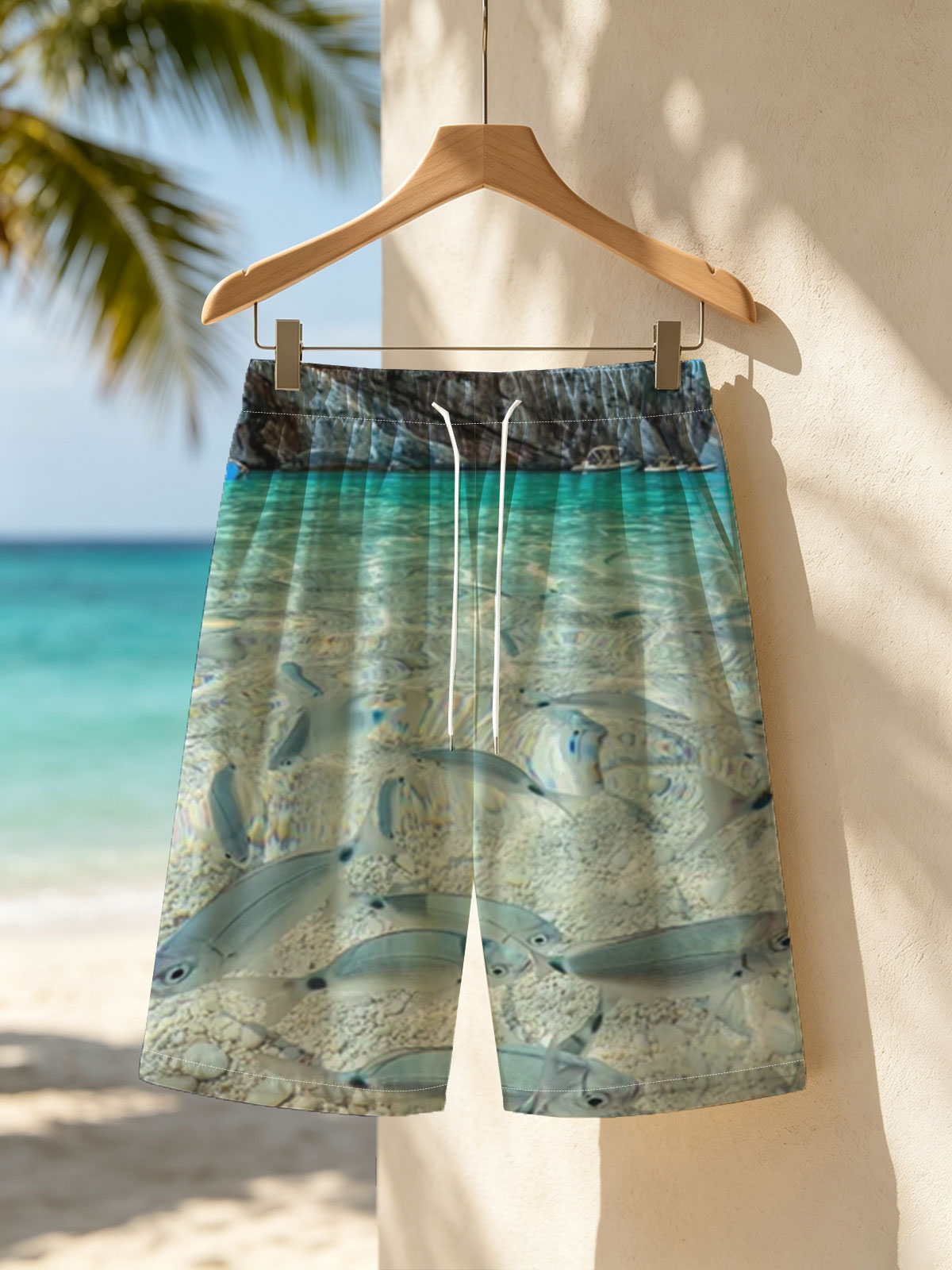 Clear waters reveal schools of fish swimming near a rocky shore with boats in the distance. -  Beach shorts