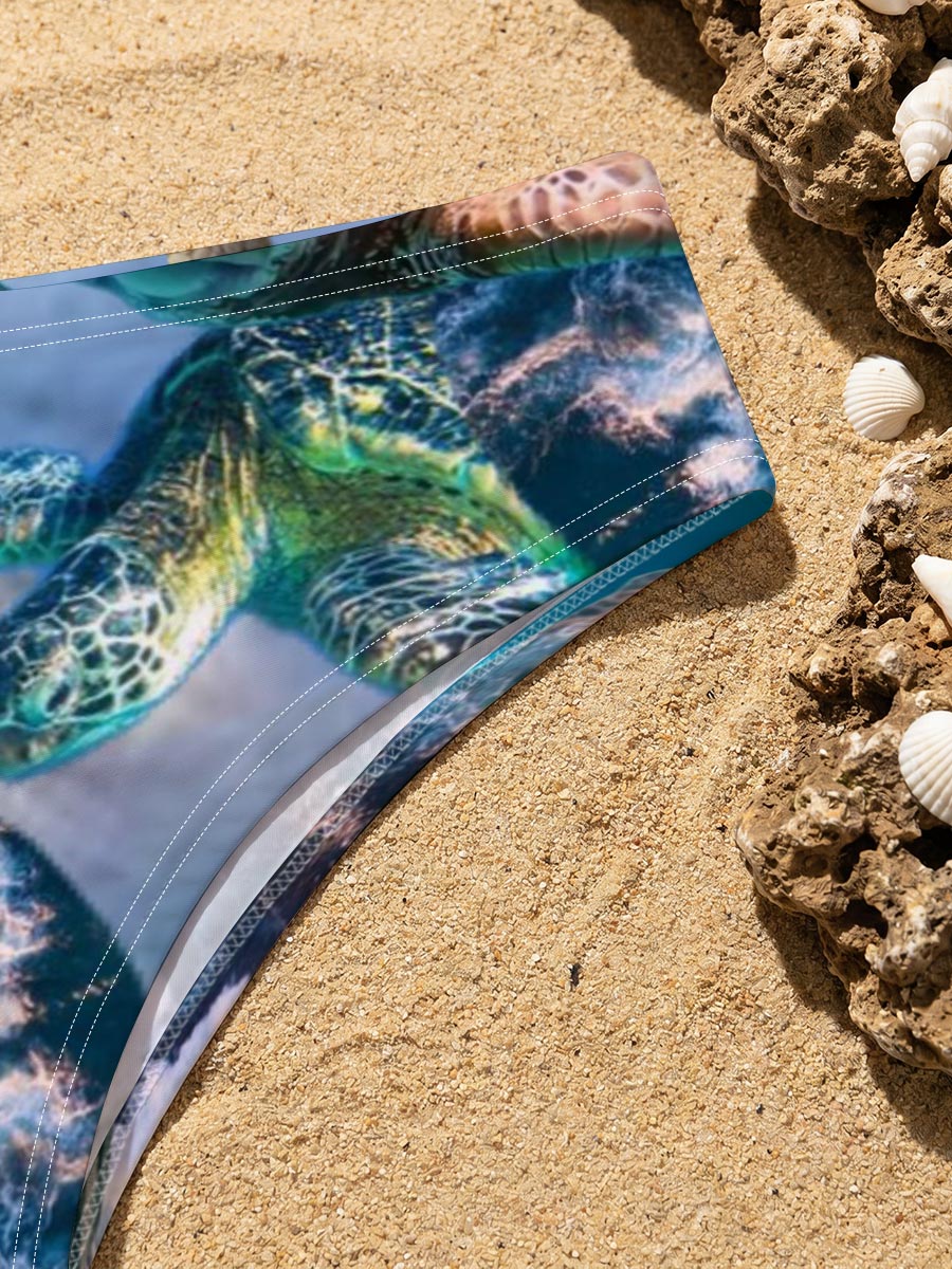Turtles, stars, and flowers in a heart-filled ocean scene -  Men's swim trunks