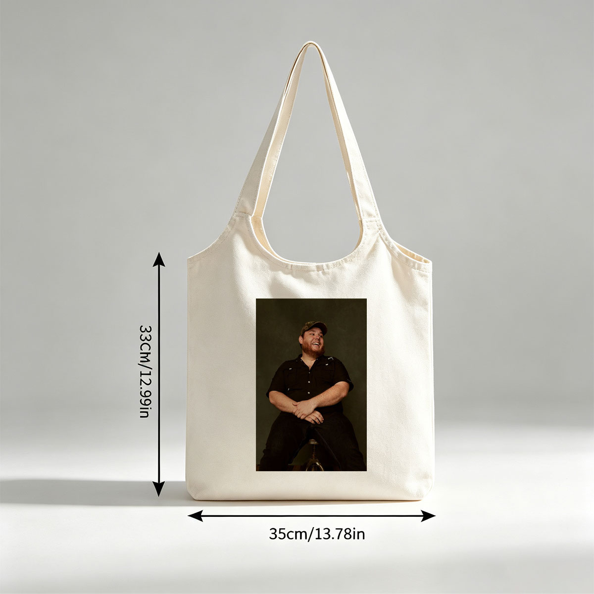 Luke Combs Sitting on a Stool Laughing in a Black Shirt and Cap - Canvas shoulder bags/