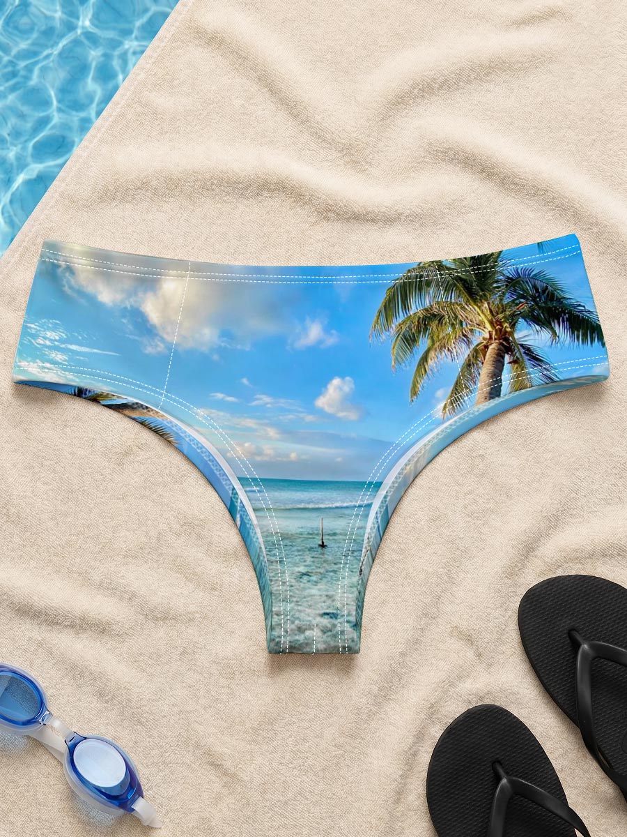 Tropical beach with palm tree leaning over clear blue water under a bright sky. -  Men's swim trunks