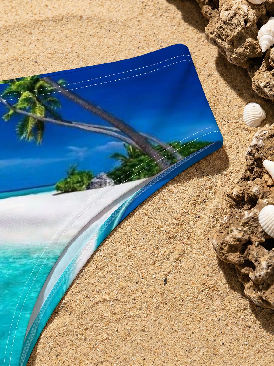 Serene tropical beach with crystal clear turquoise water and leaning palm trees under a vibrant blue sky. -  Men's swim trunks