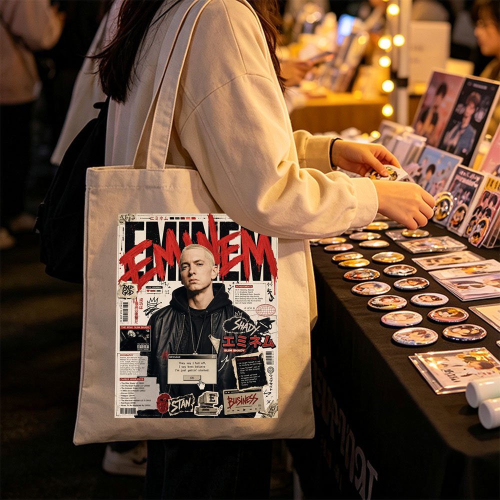 Eminem on a vibrant magazine cover featuring bold red text, career highlights, and iconic album references. - Canvas tote bags