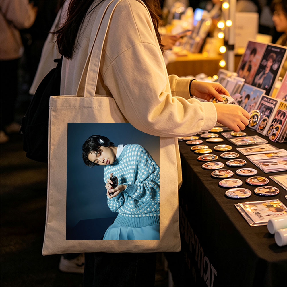 Jaden Smith in a Stylish Blue Sweater Holding a Perfume Bottle with Headphones On - Canvas tote bags