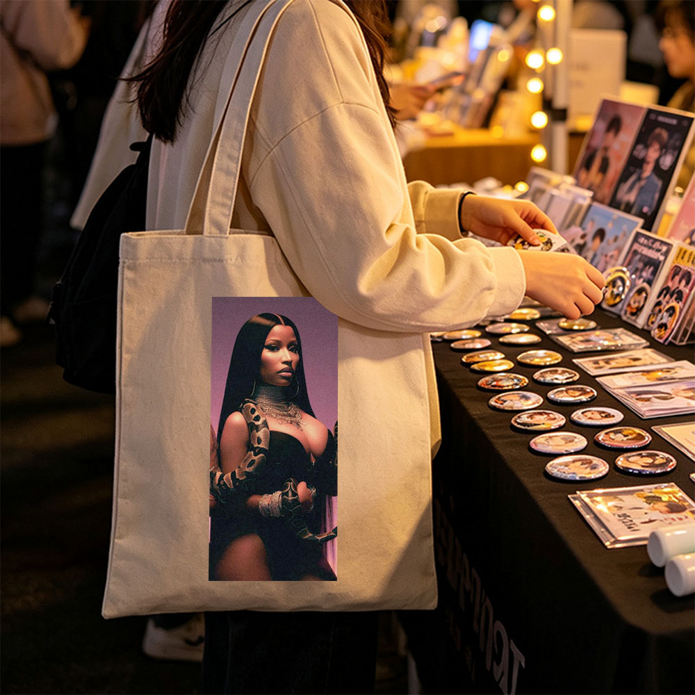 Nicki Minaj in a Dramatic Pose with a Snake Wrapped Around Her Arm and Neck, Wearing a Black Outfit and Heavy Jewelry - Canvas tote bags