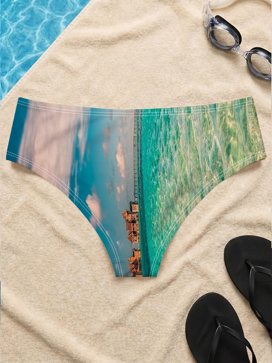 Overwater bungalows stretch into turquoise waters under a vibrant sky. -  Men's swim trunks