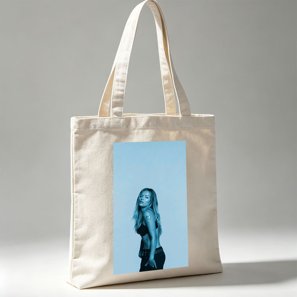 Khloe Kardashian in a Bold Pose with Heart Tattoo and Edgy Fashion Against a Cool Blue Backdrop - Canvas tote bags