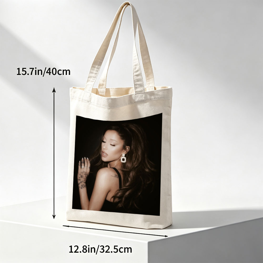 Ariana Grande in a Dramatic Pose with Long Hair and Tattoos on Dark Background - Canvas tote bags