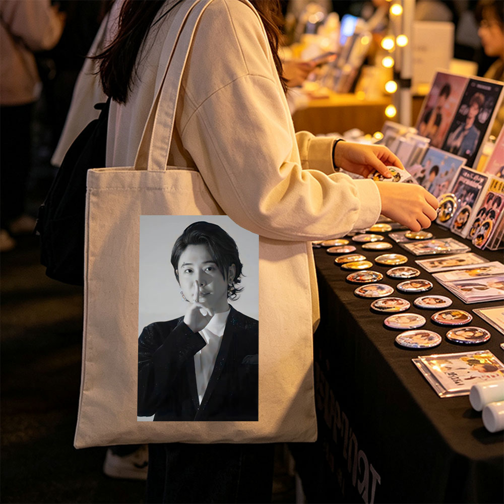 Kai from EXO in a dramatic pose with finger on lips, wearing a sparkling black suit and white shirt, set against a neutral background. - Canvas tote bags