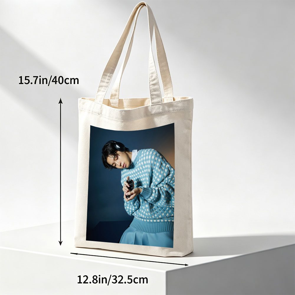 Jaden Smith in a Stylish Blue Sweater Holding a Perfume Bottle with Headphones On - Canvas tote bags
