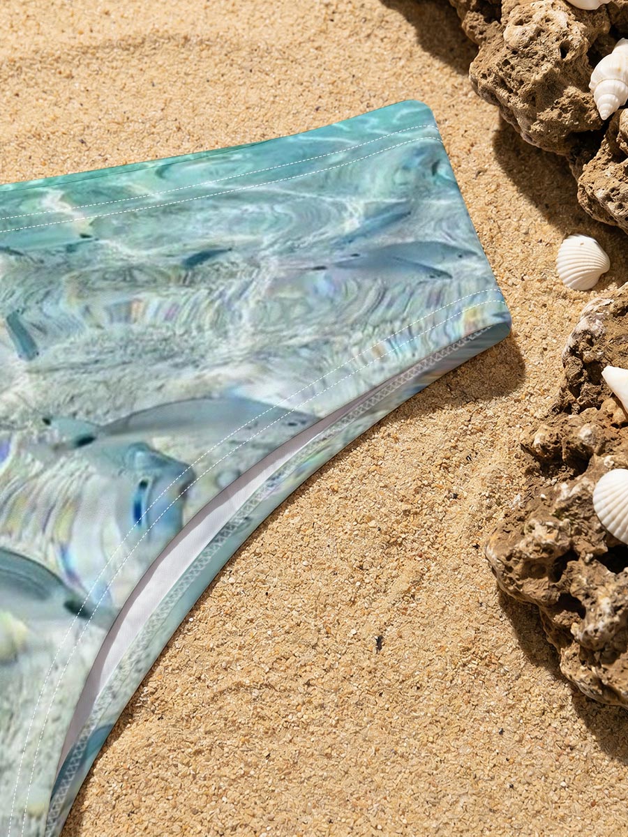 Clear waters reveal schools of fish swimming near a rocky shore with boats in the distance. -  Men's swim trunks