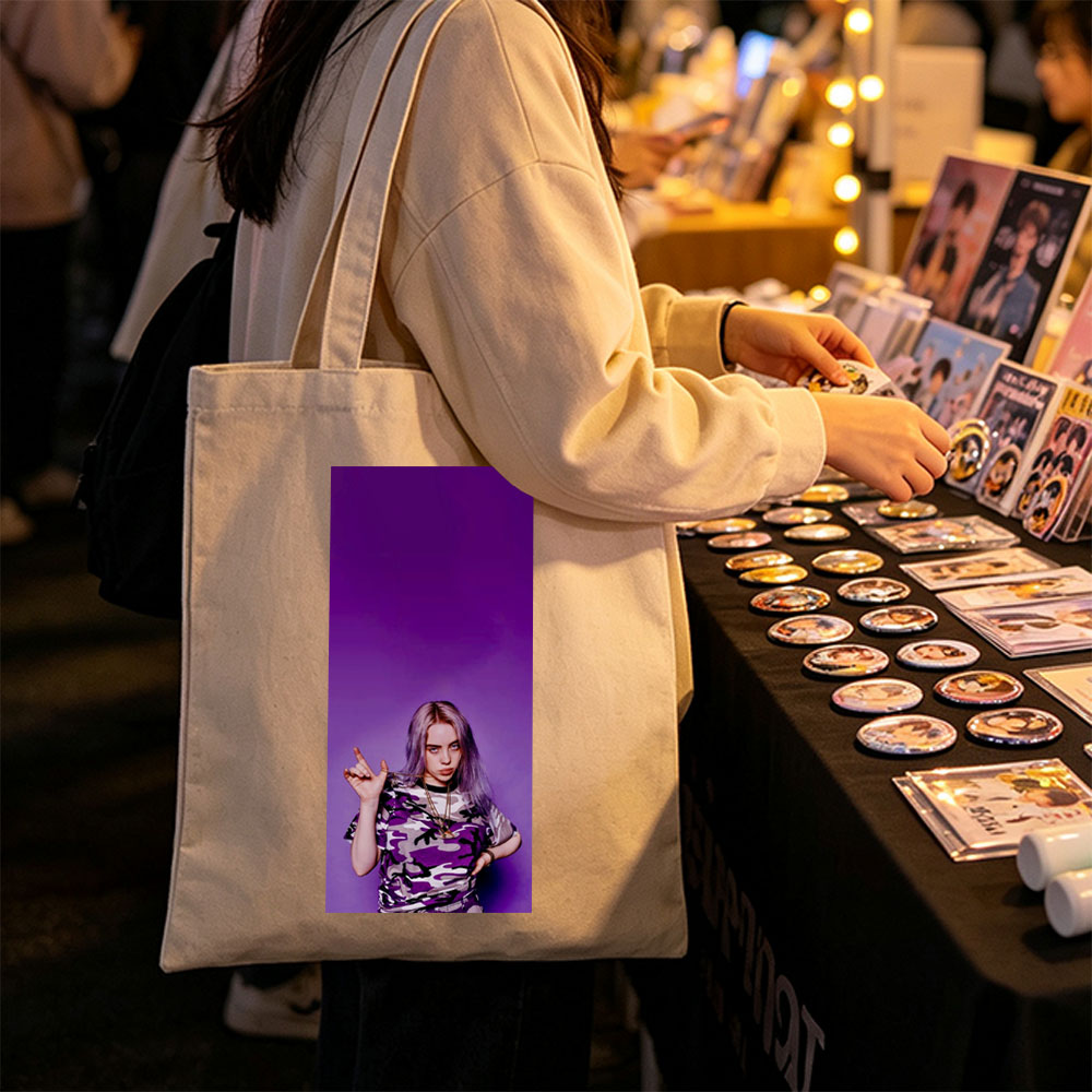 Billie Eilish in Purple Camo Outfit Making Hand Gesture Against Vibrant Background - Canvas tote bags