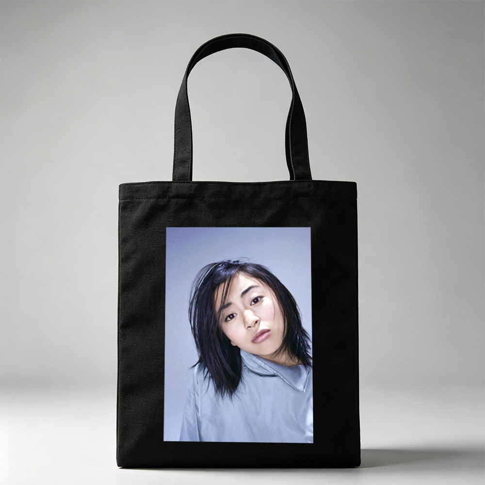 Yuki Kajiura in a Serene Portrait Wearing a Light Blue Collared Shirt Against a Soft Gray Background - Canvas tote bags