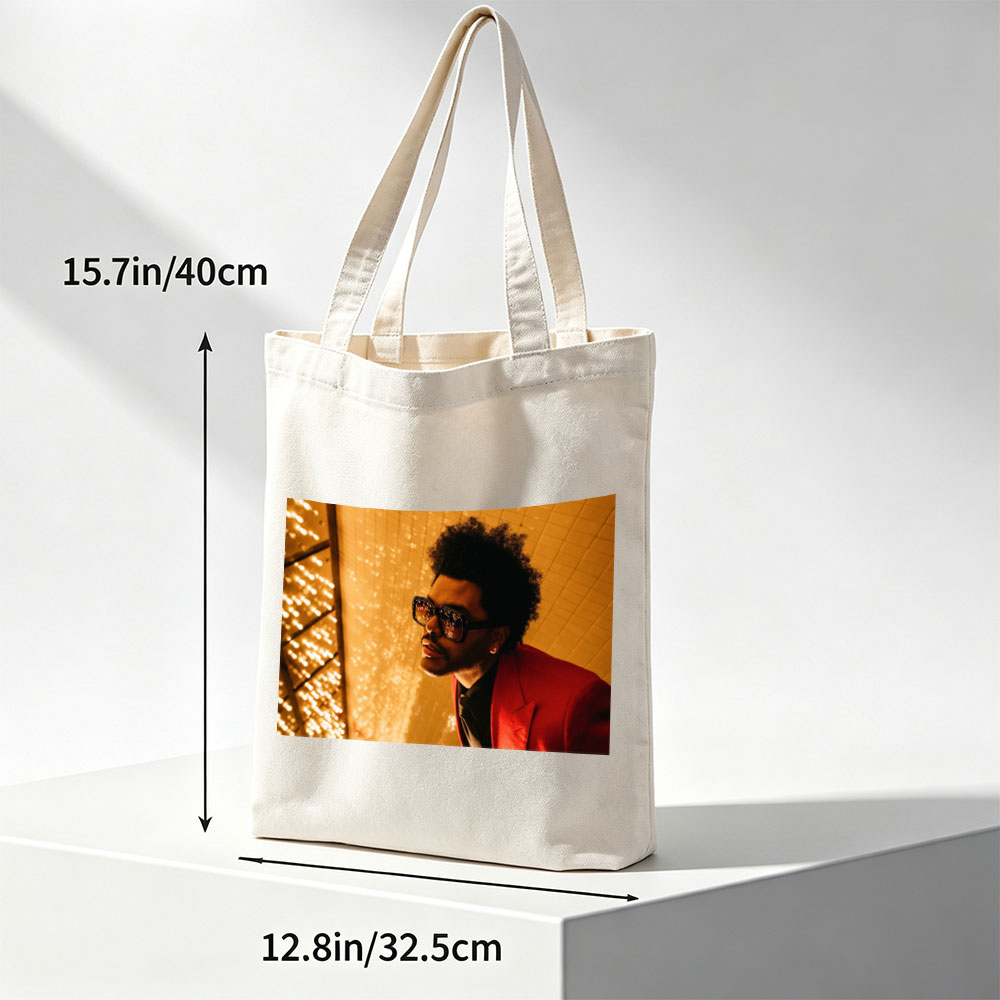 The Weeknd in a Red Suit and Sunglasses Against a Golden Lighted Background - Canvas tote bags