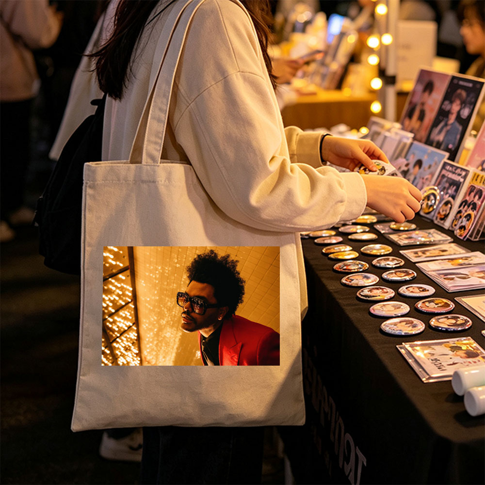 The Weeknd in a Red Suit and Sunglasses Against a Golden Lighted Background - Canvas tote bags