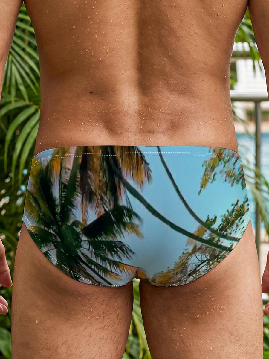 Tropical palm trees sway under a clear blue sky, casting golden shadows on the ground. -  Men's swim trunks
