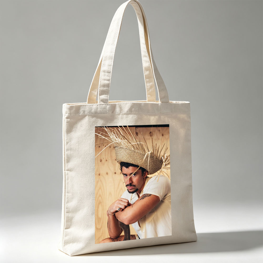 Bad Bunny Wearing a Straw Hat with Hay Sticks, Leaning Against a Wooden Wall in a Casual Pose - Canvas tote bags